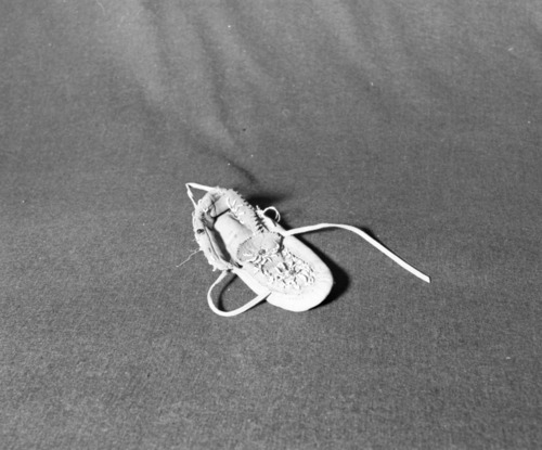 Marie Rozier Collection, Catalog No. 228. Object: unidentified moccasin. Dimensions: 8". Materials: commercial buckskin, red glass beads. Technology: apparently a remnant of Native American pageants popular in 1920s. Collection History: found by San Joaquin River June 1922-23, 11 miles south of Madera on bank when water receded. Gift of Mr. & Mrs. Crowder of Clovis. Photographed by Michael Dixon, December 1982. Catalogued by Craig Bates and Barbara Beroza. Yosemite Collections, National Park Service.