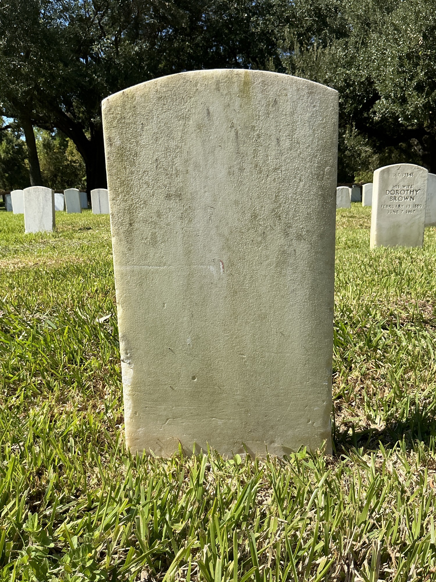 Back of historic upright marble headstone with recessed shield face.