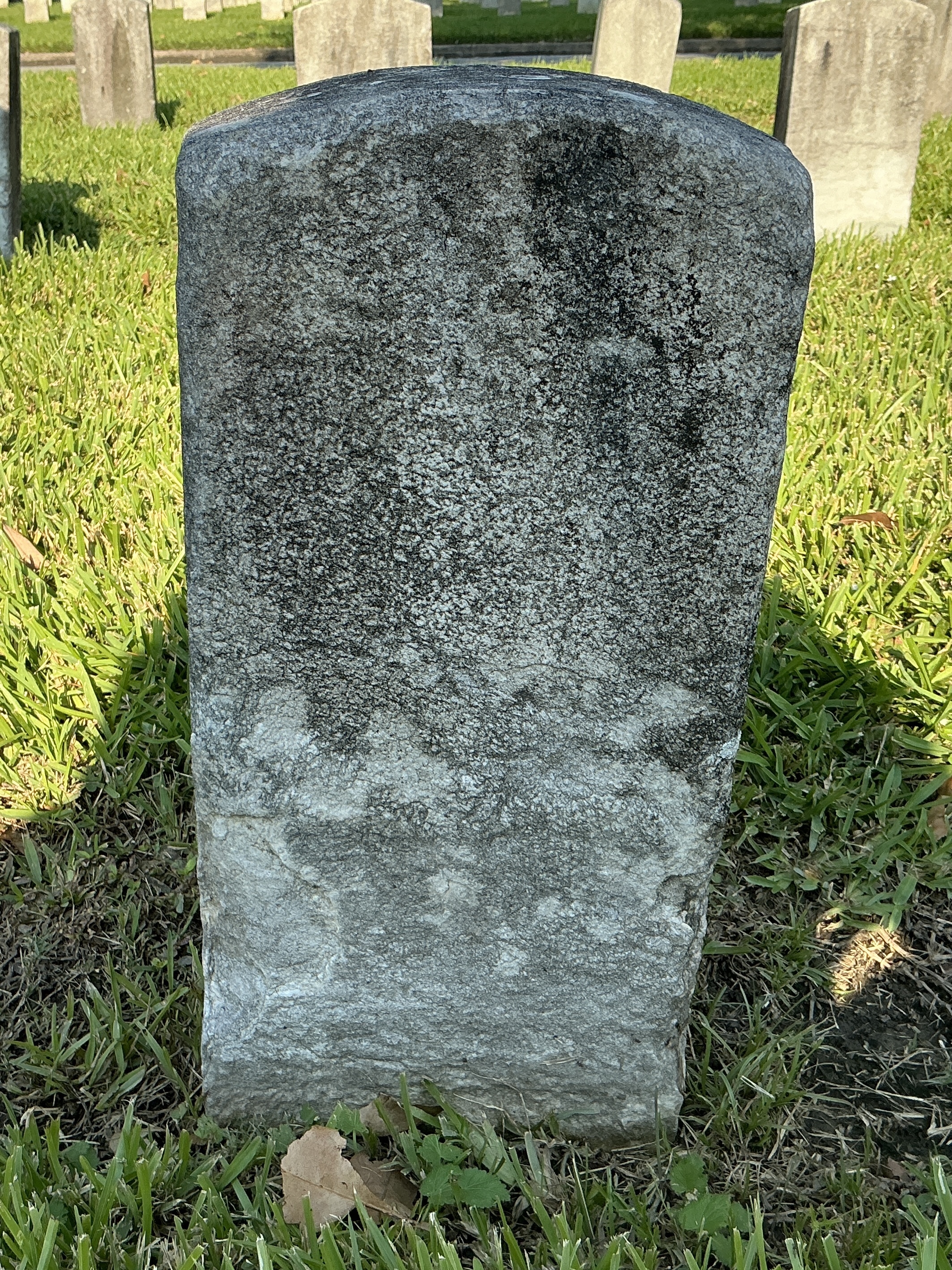Back of historic upright marble headstone with recessed shield face.