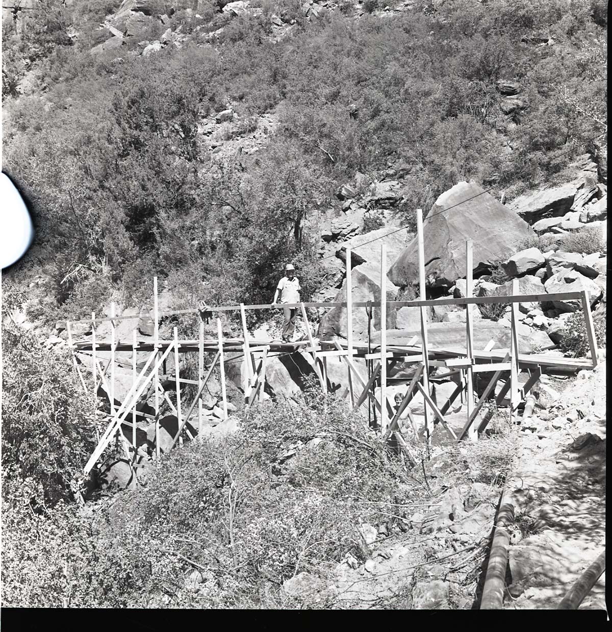 Wylie Retreat spring pipeline restoration. Worker stands on the scaffolding.