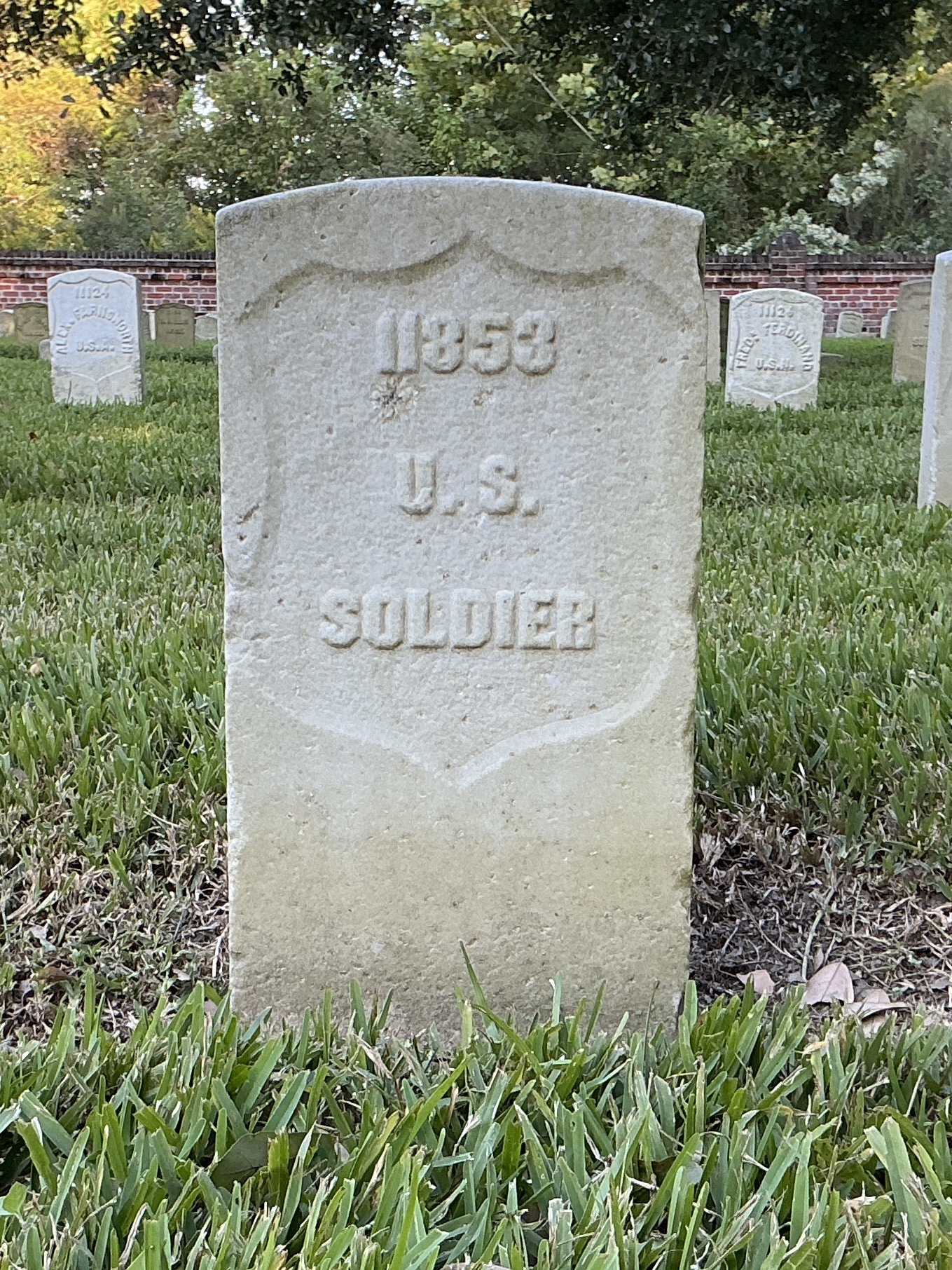 Front of historic upright marble headstone with recessed shield face.