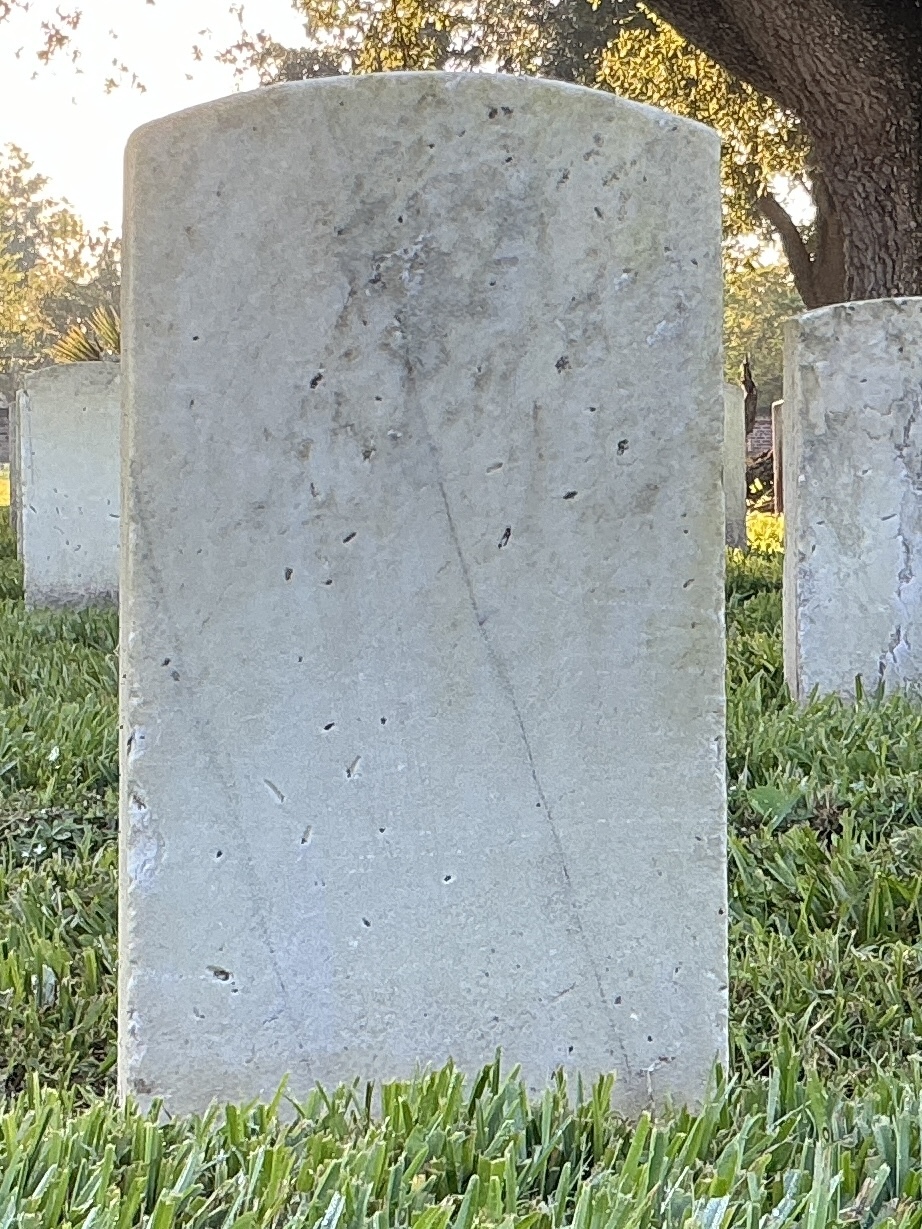 Back of historic upright marble headstone with recessed shield face.