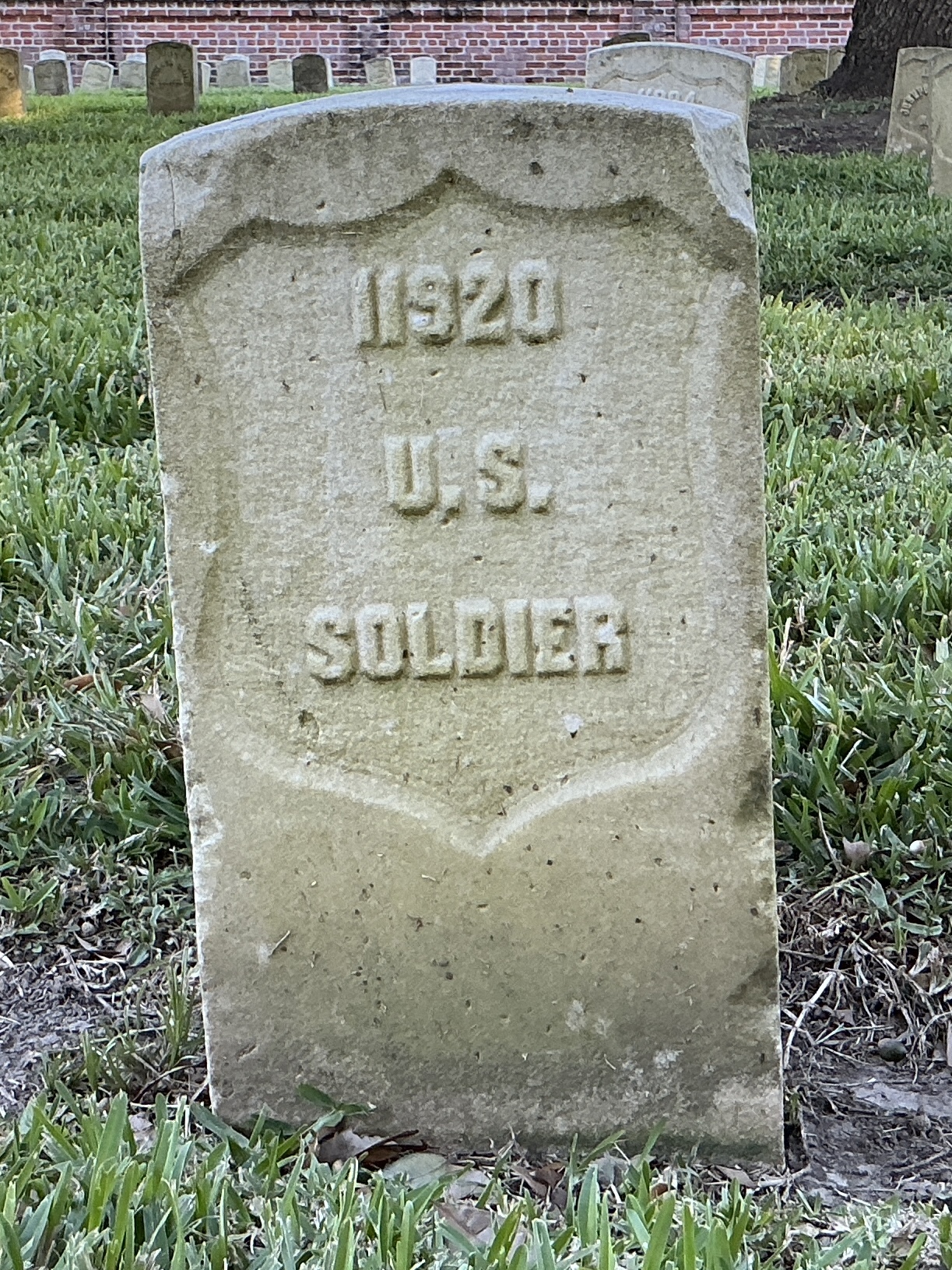Front of historic upright marble headstone with recessed shield face.
