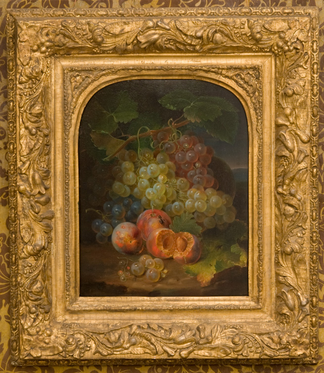 Still life of bunches of grapes and peaches in gilt frame with arched top