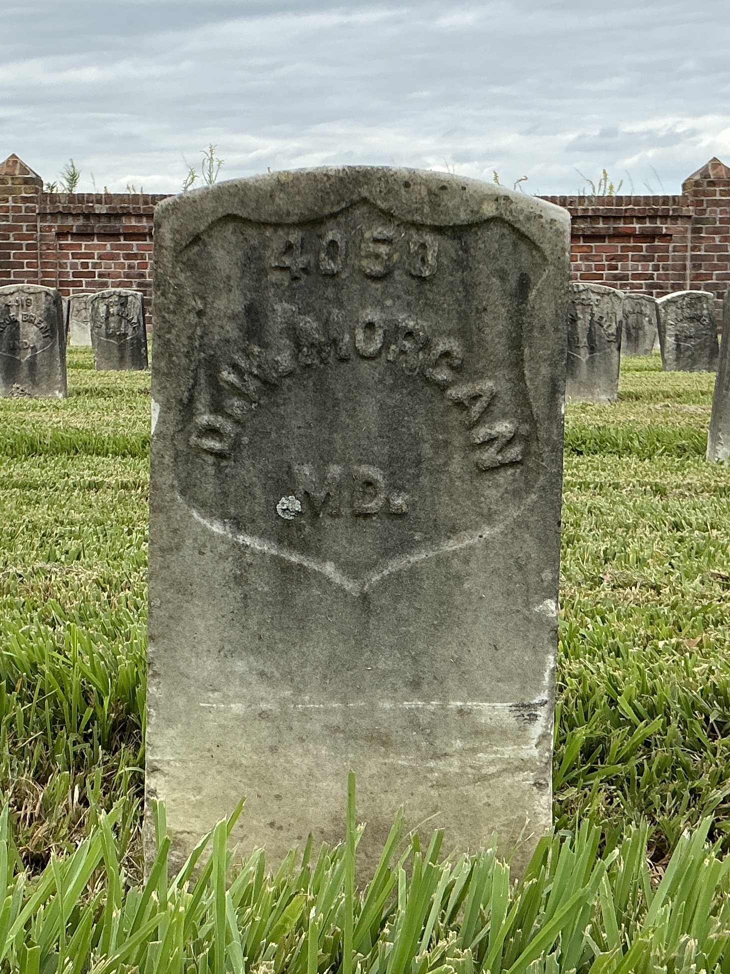 Front of historic upright marble headstone with recessed shield face.