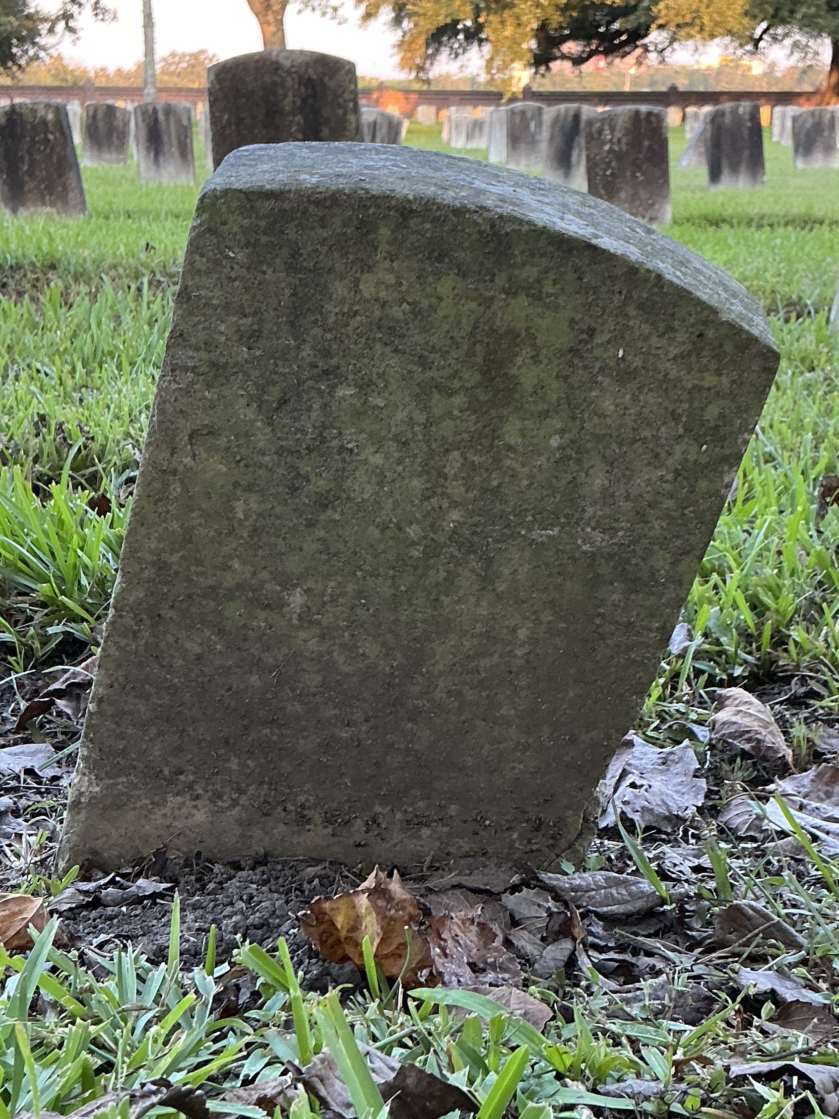 Back of historic upright marble headstone with recessed shield face.
