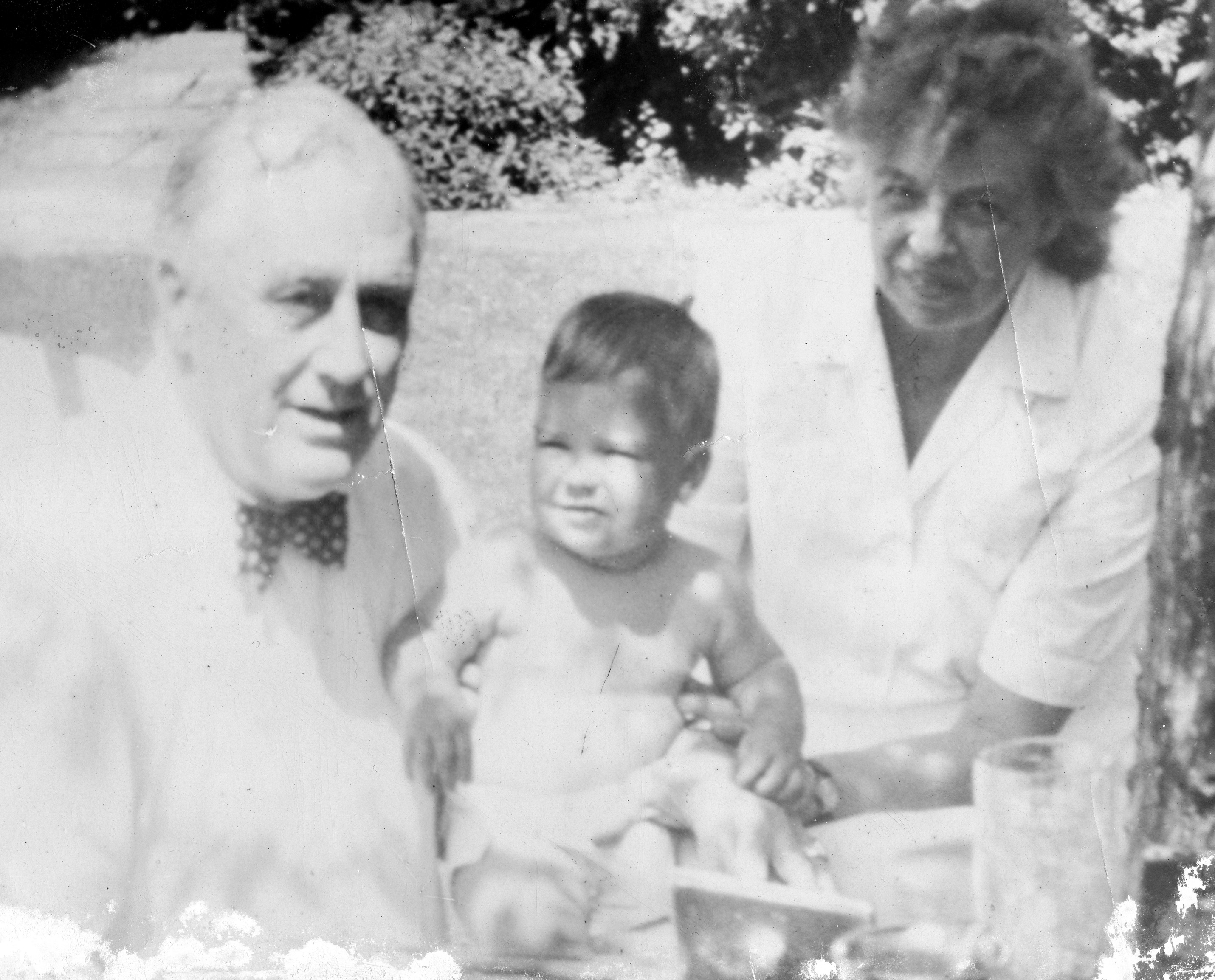 A man wearing a bow tie and a woman holding a young boy.