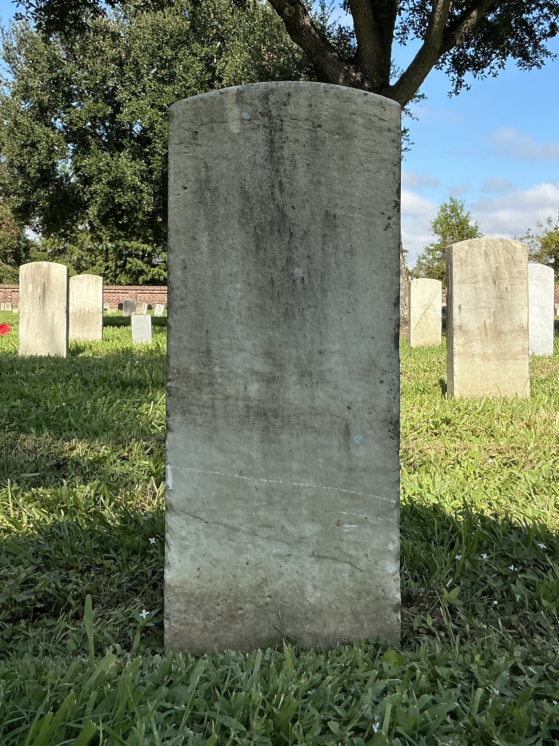 Back of historic upright marble headstone with recessed shield face.