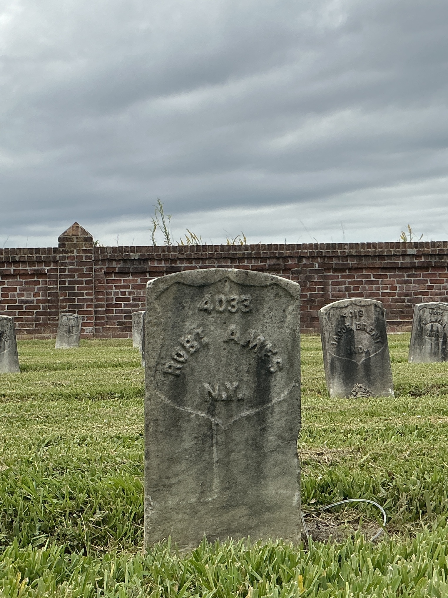 Front of historic upright marble headstone with recessed shield face.