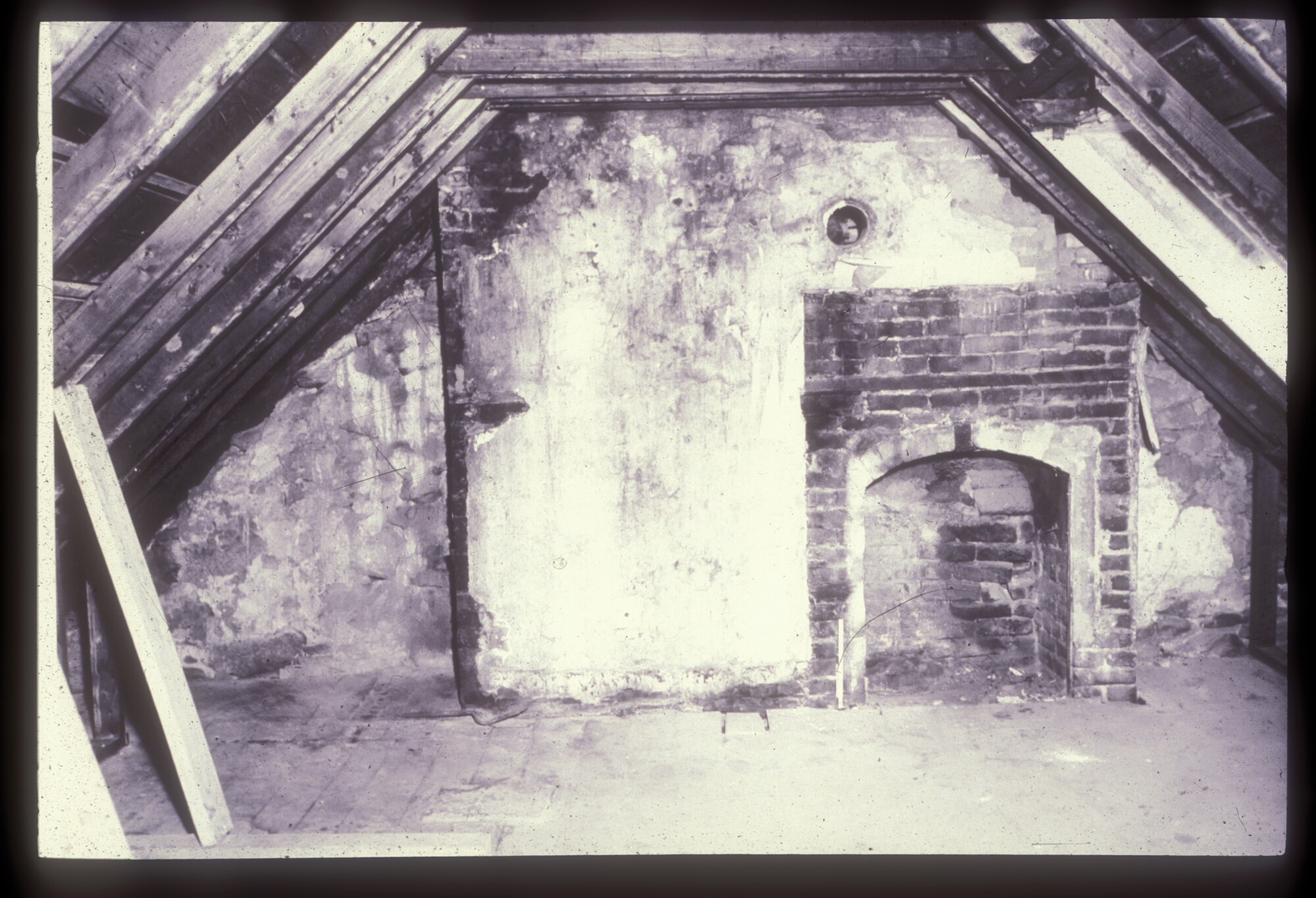 A small brick fireplace in a wall with a sharply angled ceiling