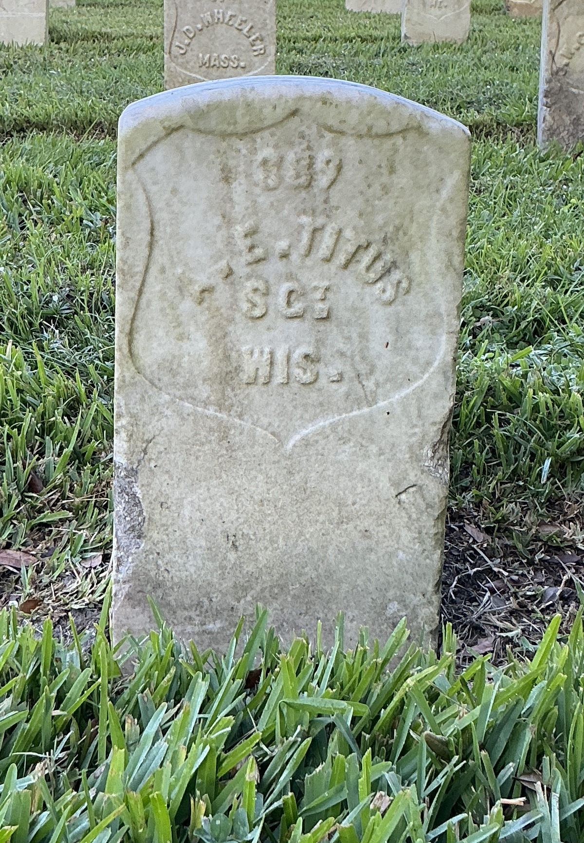 Front of historic upright marble headstone with recessed shield face.