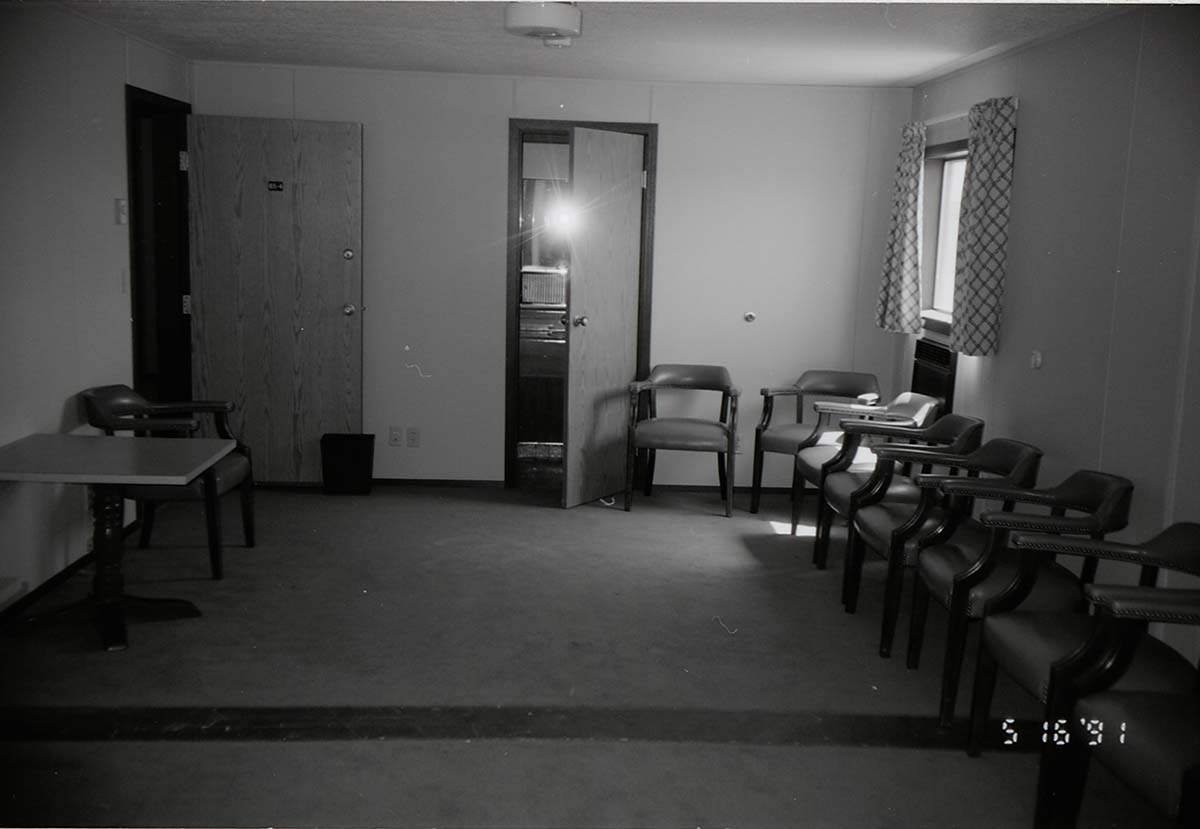 Chairs along wall of living room area in barracks. [Image possibly for comparative housing study]
