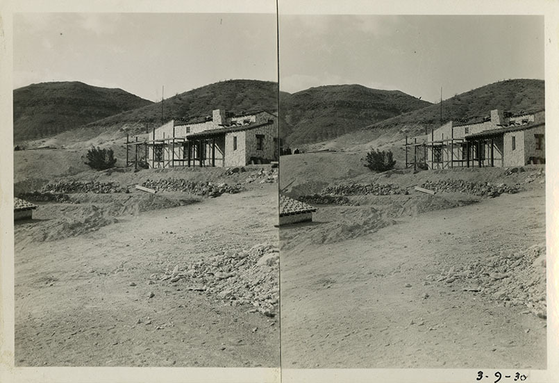 This is an historic black and white photograph from the Scotty's Castle Historic Photograph Collection, Death Valley National Park of Scotty's Castle Cook House with scaffolding. Beginning of landscape Retaining Walls construction.  March 9, 1930. Photographed by Mat Roy Thompson.
