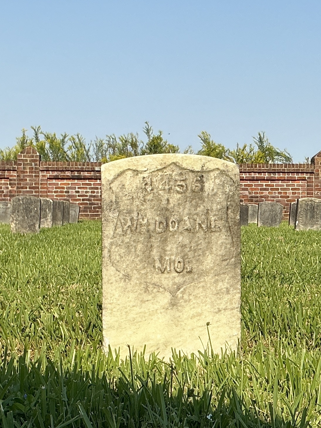 Front of historic upright marble headstone with recessed shield face.