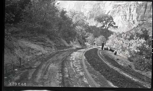 Two workers on the floor of the valley road. Labeled 'experimental road paving.'