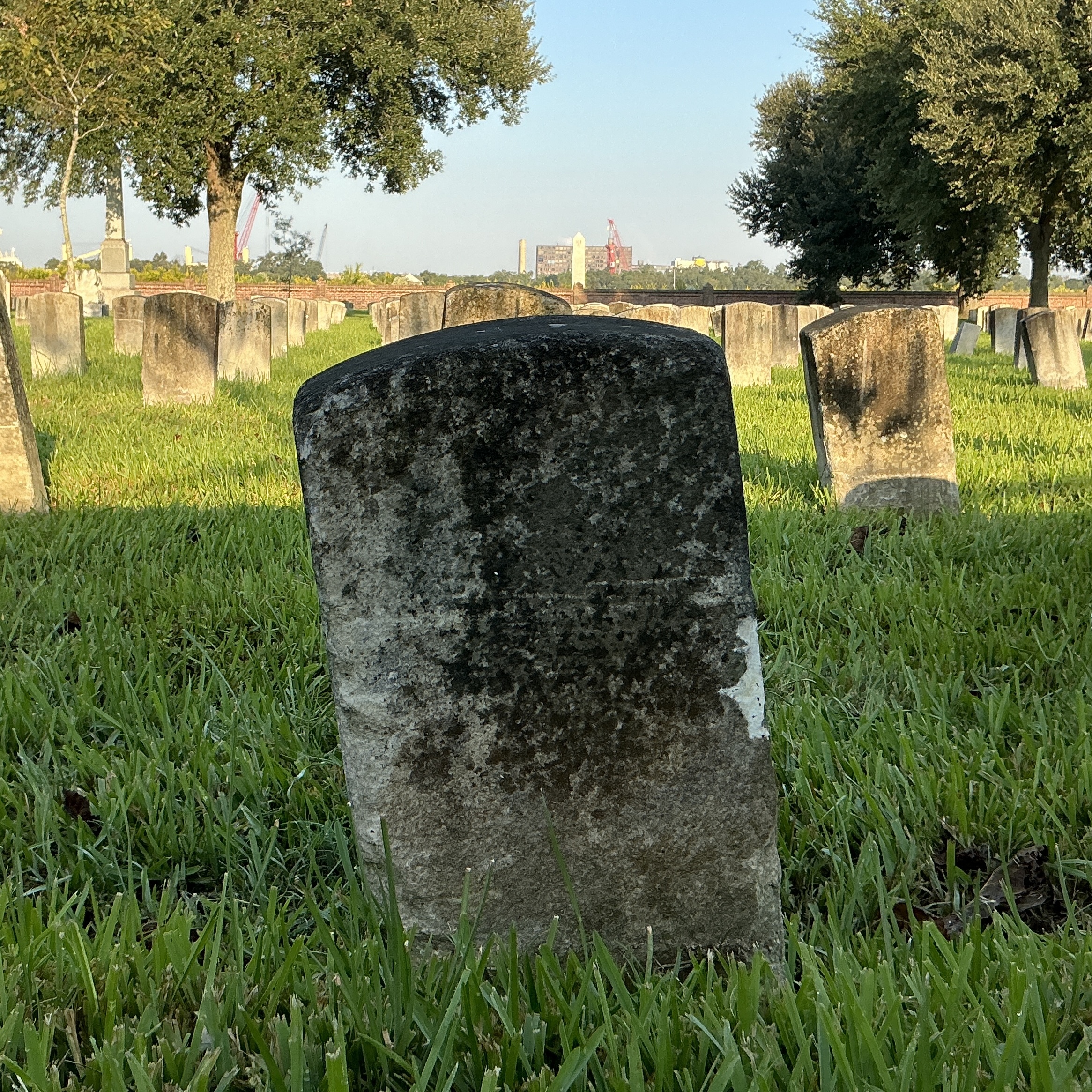 Back of historic upright marble headstone with recessed shield face.