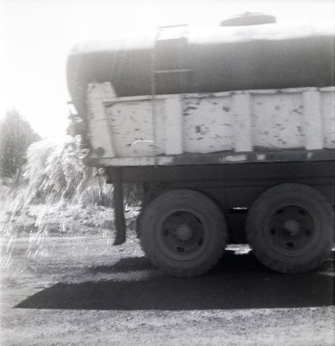 Side view of tanker truck spraying Kolob Canyon Road for chipsealing project.
