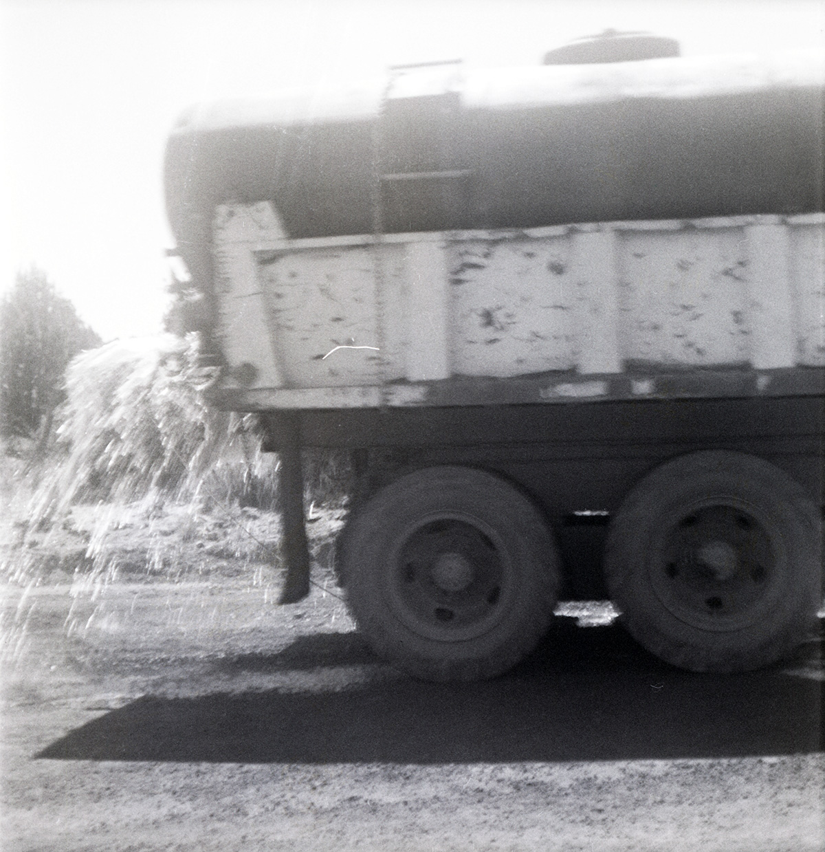 Side view of tanker truck spraying Kolob Canyon Road for chipsealing project.