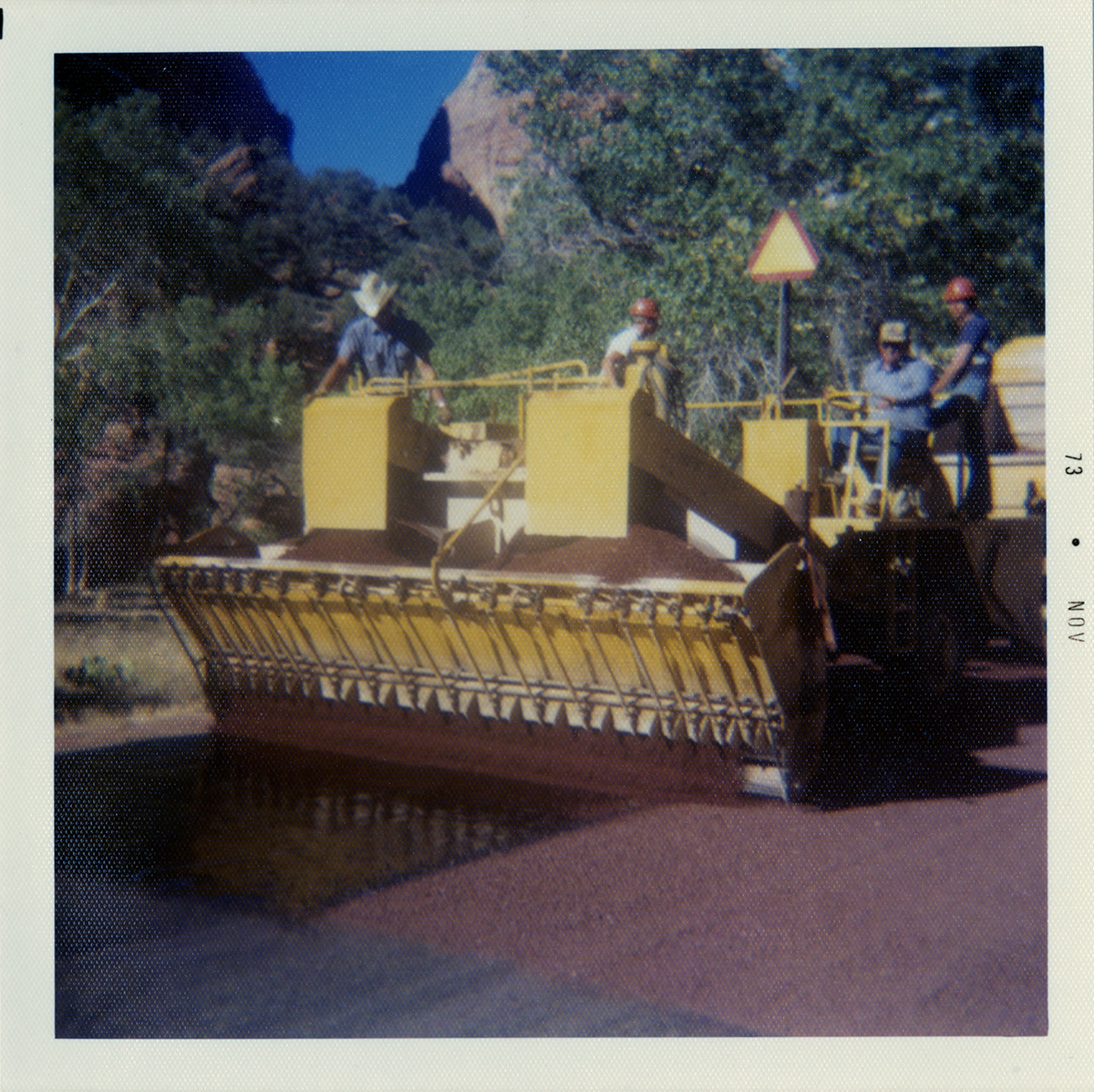 Men working on sealcoating road.