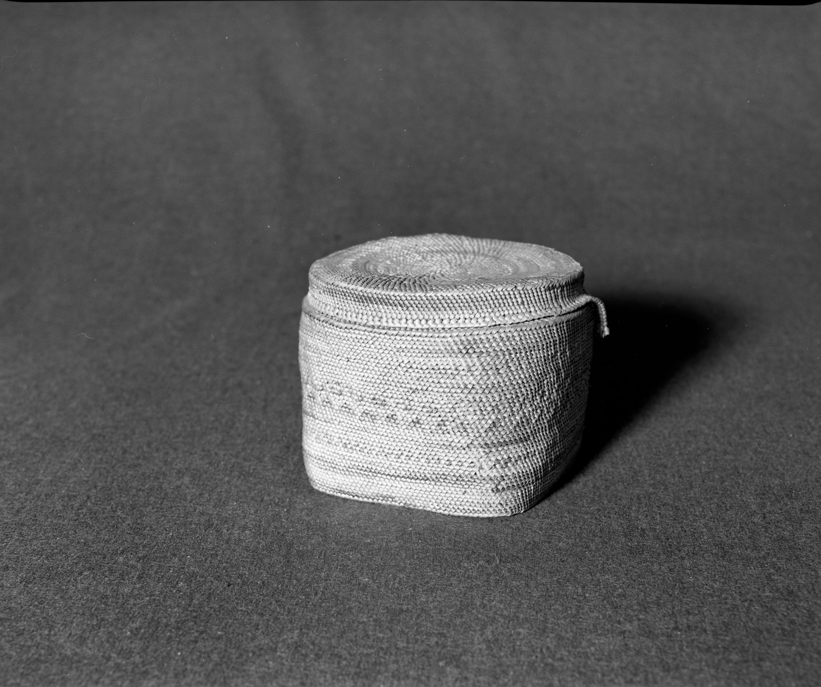 Marie Rozier Collection, Catalog No. 125. Object: Quinault basket. Dimensions: 5 x 4". Materials: Red cedar, grass. Technology: Interior shows bright purple and green dyes used, now faded on exterior. Collection History: Acquired from Ora Doyle. Photographed by Michael Dixon, December 1982. Catalogued by Craig Bates and Barbara Beroza. Yosemite Collections, National Park Service.