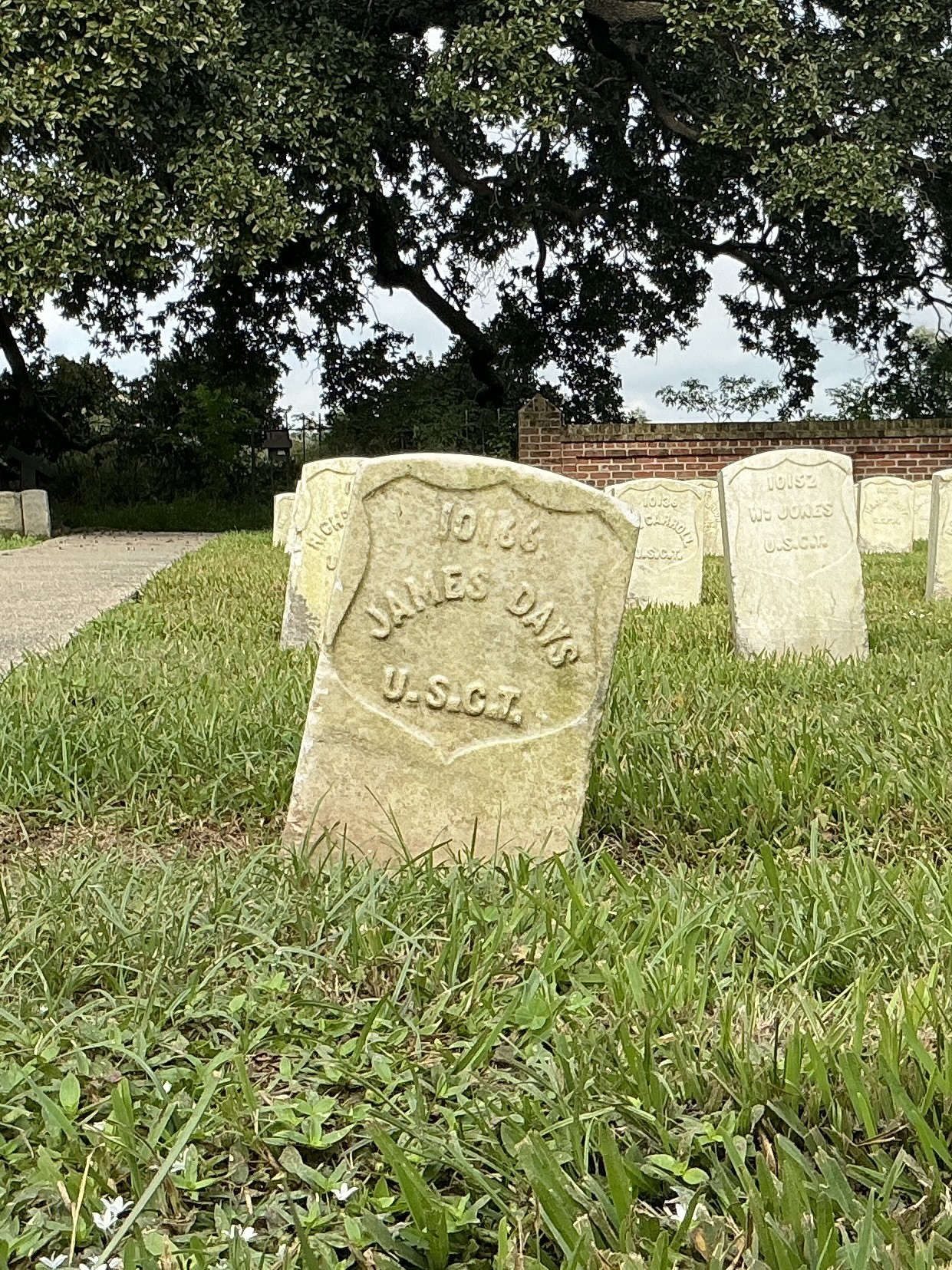 Front of historic upright marble headstone with recessed shield face.