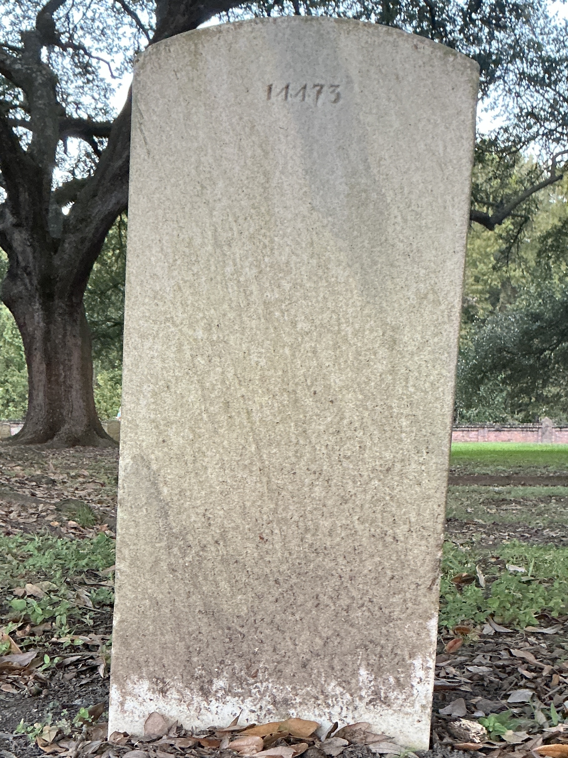 Back of upright marble headstone with flat face.