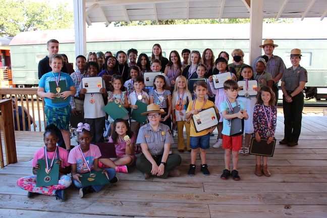 2023 Plains Peanut Festival Post Card Contest Winners posing with awards and park rangers. 