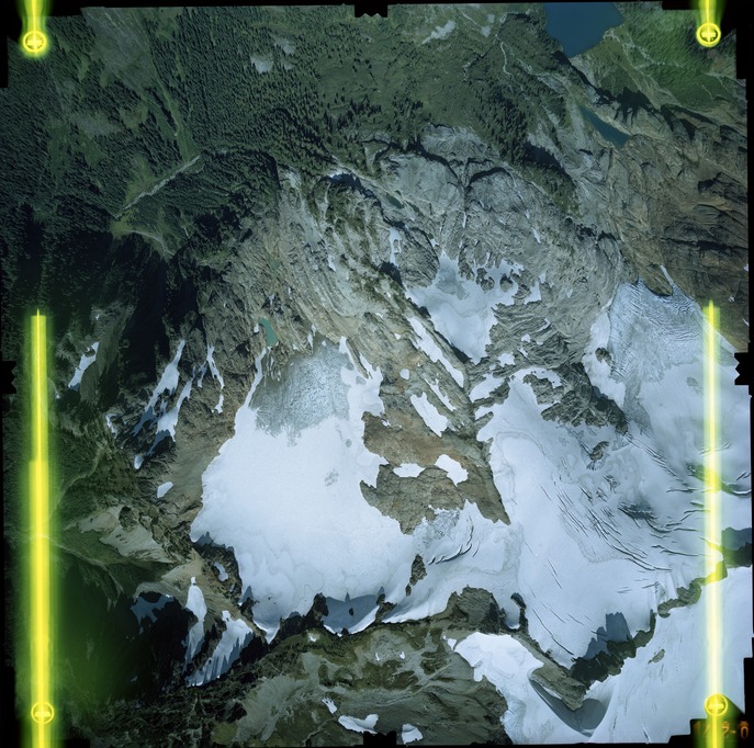 Color aerial photograph of glacier on mountain peak.