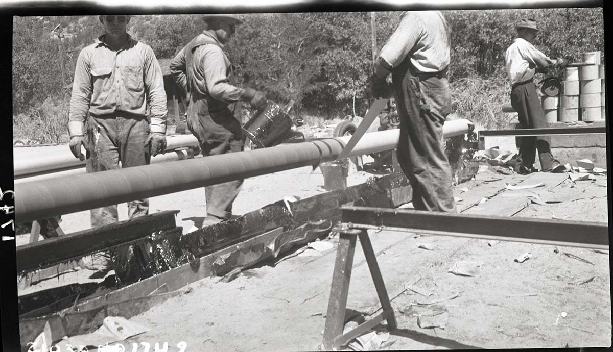 Applying Kraft paper over the felt on the waterline from Birch Creek to park headquarters alongside the park road in Zion Canyon.