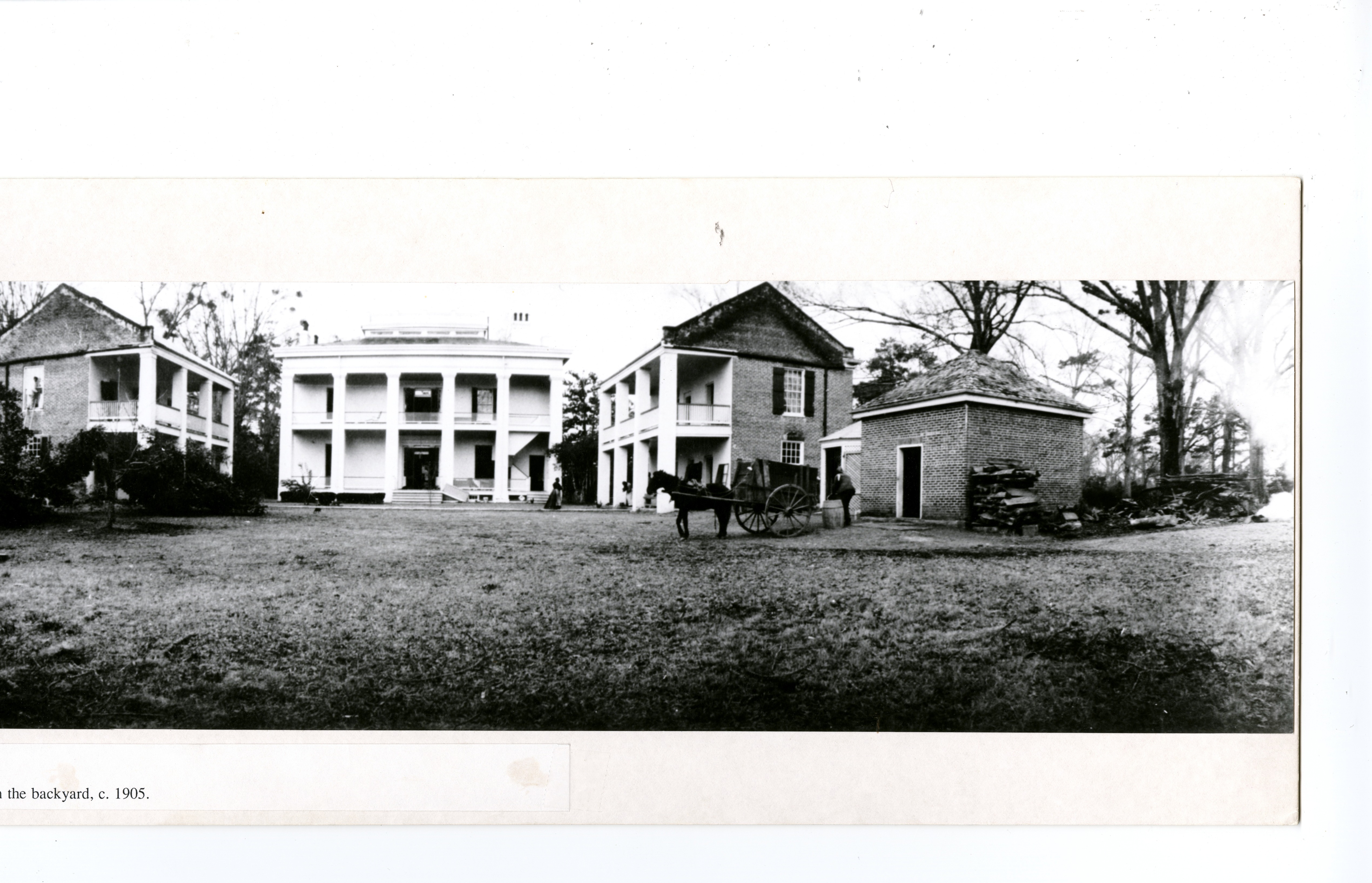 large mansion with matching outbuilding forming a half square