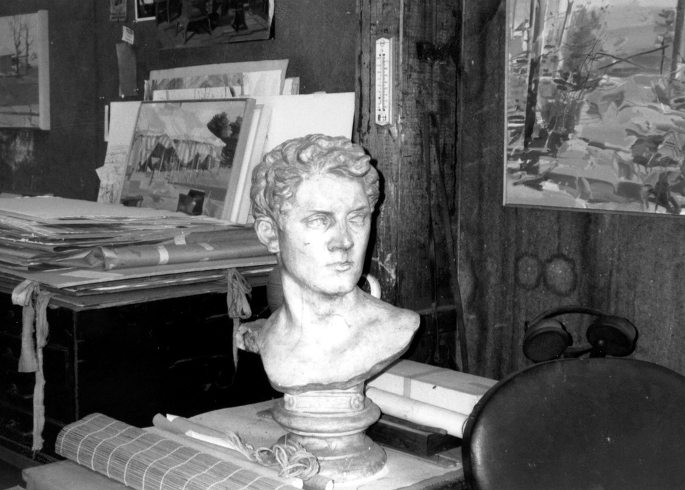 A bust of man on a table in a studio.