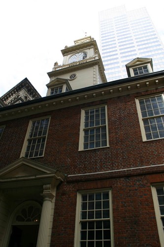 A modern building looms over the Old State House in Boston