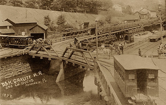 This photograph shows the Honesdale docks in 1898, the last year of operation for the canal. While the rail cars on the left are loaded with passengers instead of coal, in the background can still be seen boats in the process of loading coal.