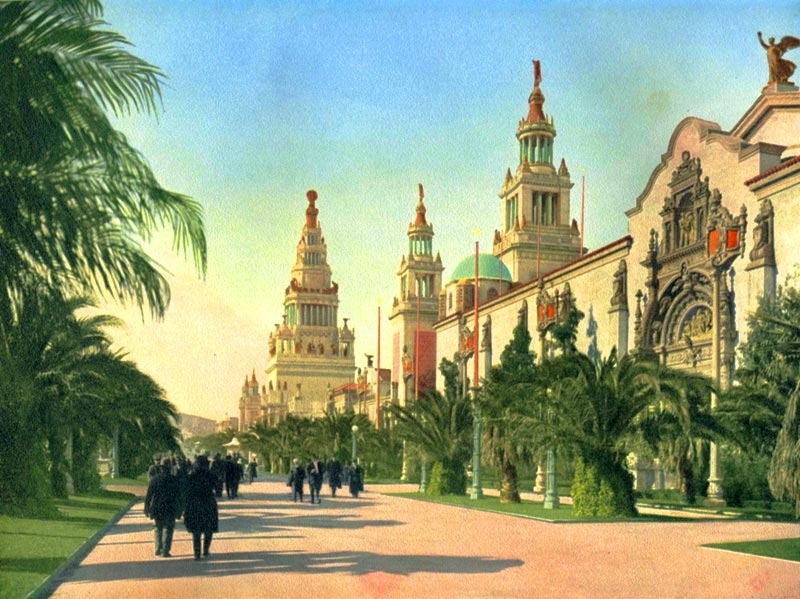 Palm Avenue, shown in this historic colored postcard, was the main thoroughfare between the great South Gardens and the group of main exhibit palaces. Beautiful California palms lined either side of the avenue. On the right is the entrance to the Palace of Varied Industries, following which are two 200' tall Italian towers, each on either side of the entrance to the Court of Flowers.
