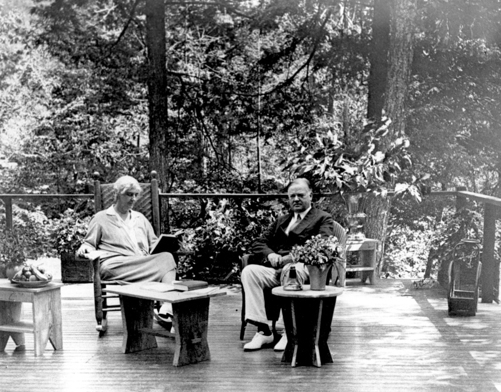 Herbert & Lou Henry Hoover seated on porch.