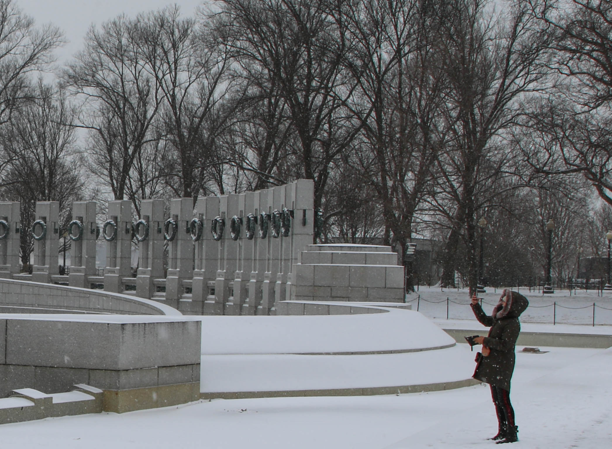 Visitor taking a photo by the World War II Memorial