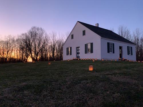small one room white building w/ orange purple sunset sky