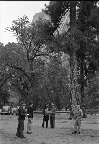 Copy Neg: Mike Floyd, 1992. Site of Lamon's cabin at the Y. P. & C. Co. stables. Two men in the middle are Chris Brown (Chief Lemee) and Ranger Bert Harwell.