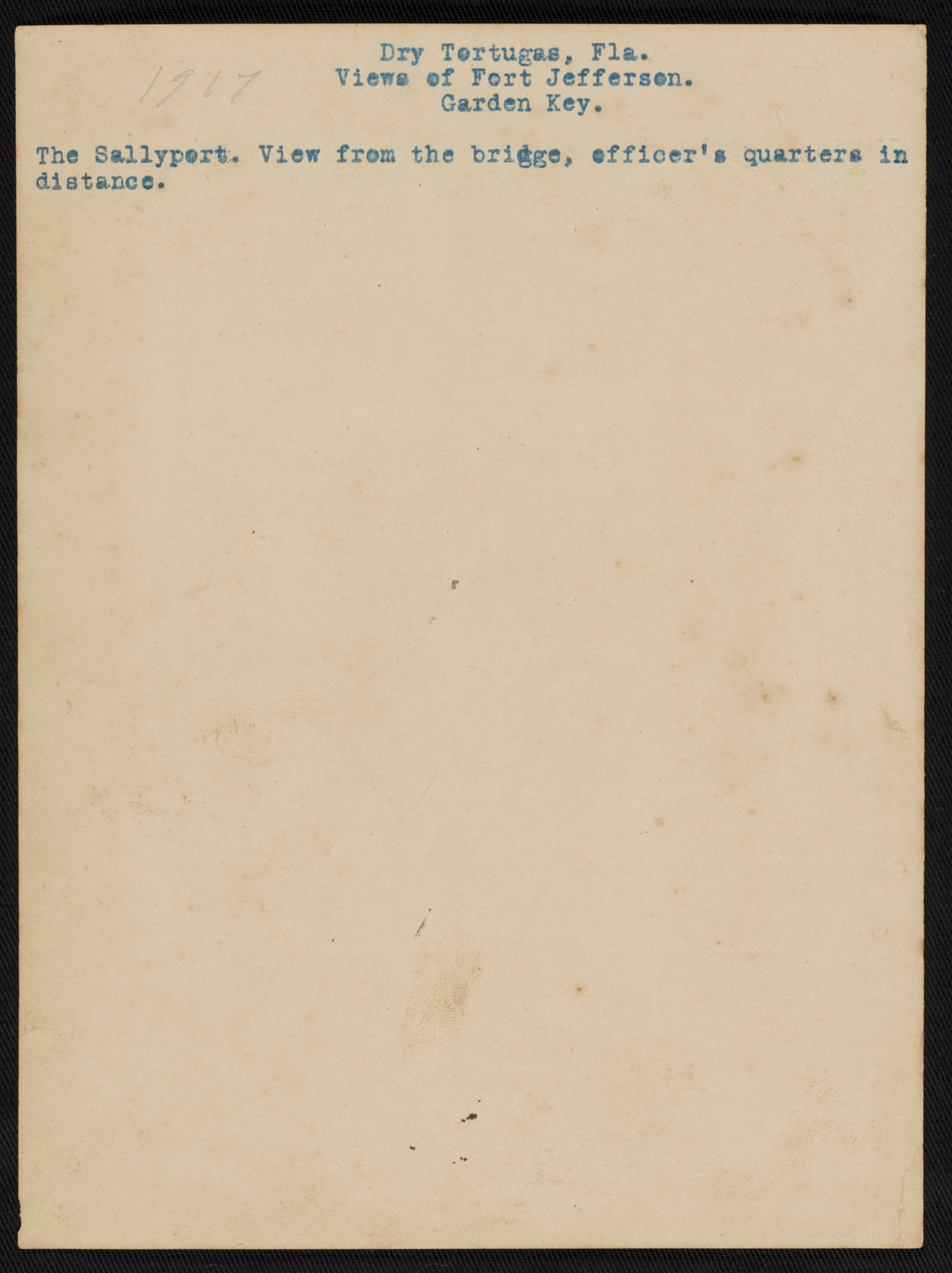 Reverse of photo with text "Fort Jefferson Sallyport view from the bridge. Officer’s Quarters in the distance."