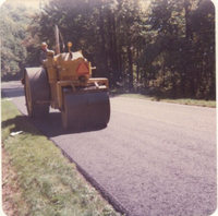 Three-wheel breakdown roller immediately behind paver