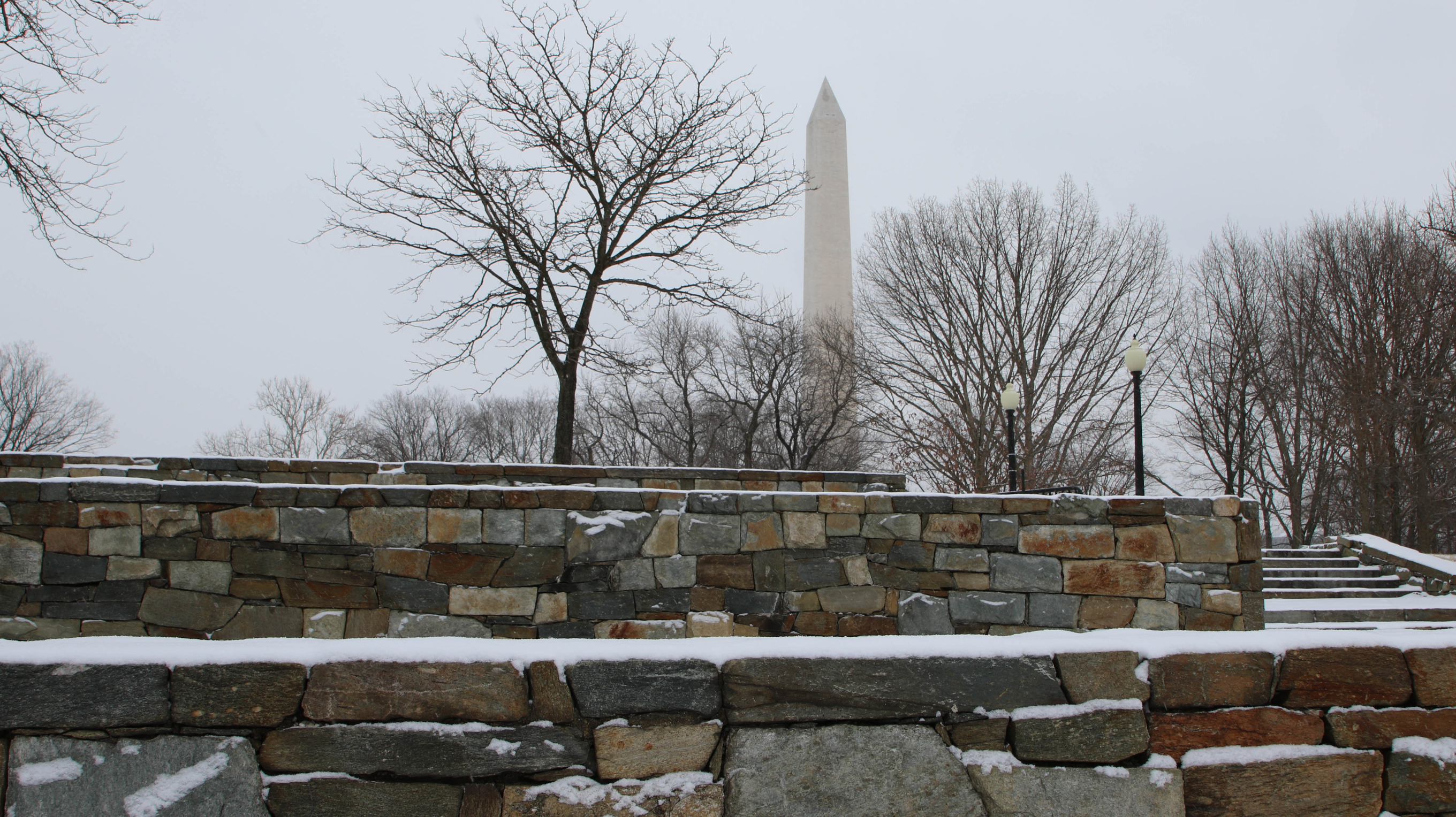 Washington Monument behind several snow-covered stone walls