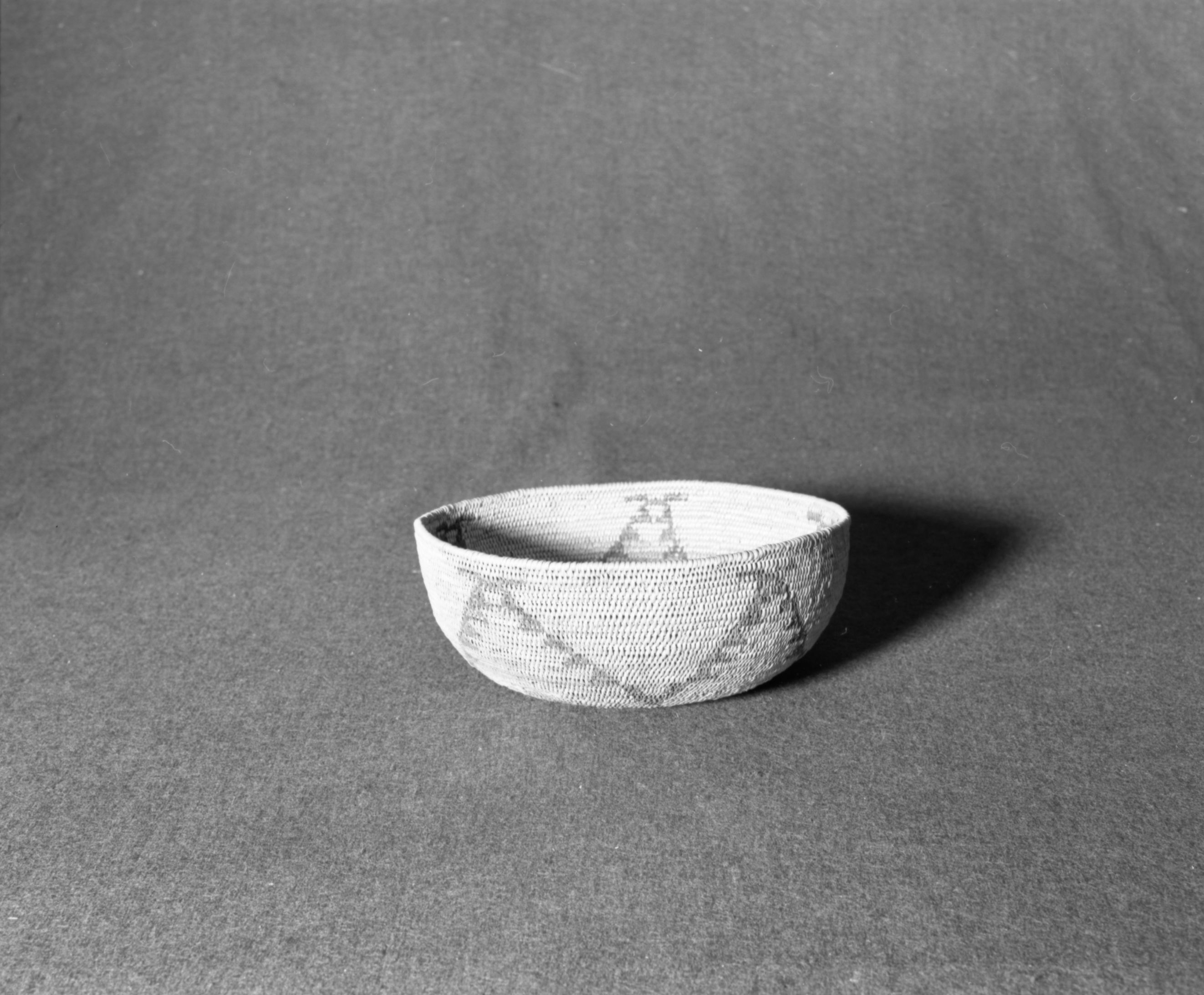 Marie Rozier Collection, Catalog No. 198. Object: Miwok basket. Dimensions: 7 1/4 x 3". Materials: split bull pine, split redbud, foundation grass and rod. Technology: interlocking stitch, leftward coil direction, clockspring start, fag ends trimmed on work face, moving ends trimmed on interior. Collection History: given to Mrs. Mark Baker by her father William P. Shutze, who received it from a local Native American lady (name forgotten) in payment for groceries from his store in 1922. Acquired from Mrs. Baker in 1970. Photographed by Michael Dixon, December 1982. Catalogued by Craig Bates and Barbara Beroza. Yosemite Collections, National Park Service.