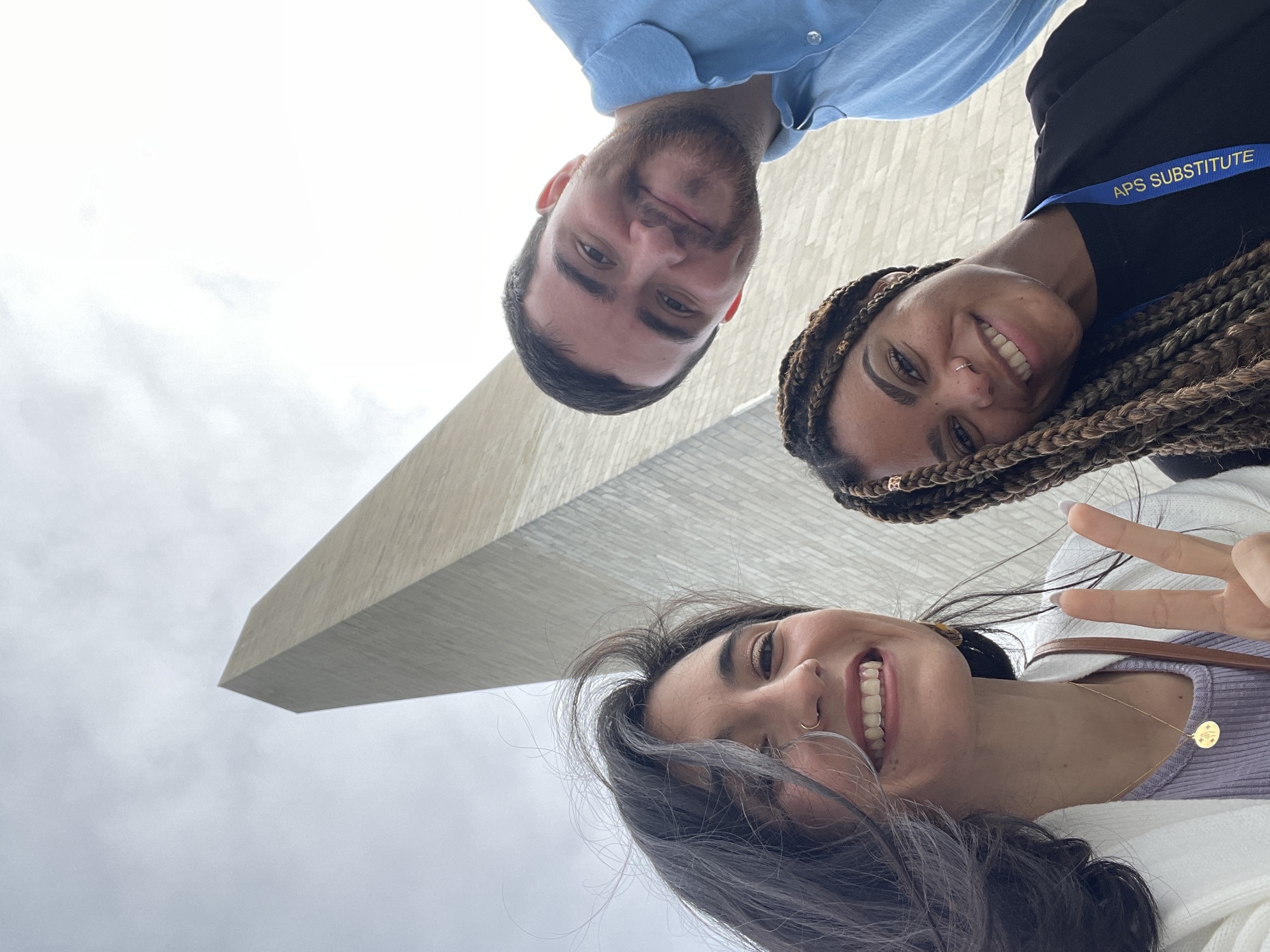 Three people standing in front of the Washington Monument.