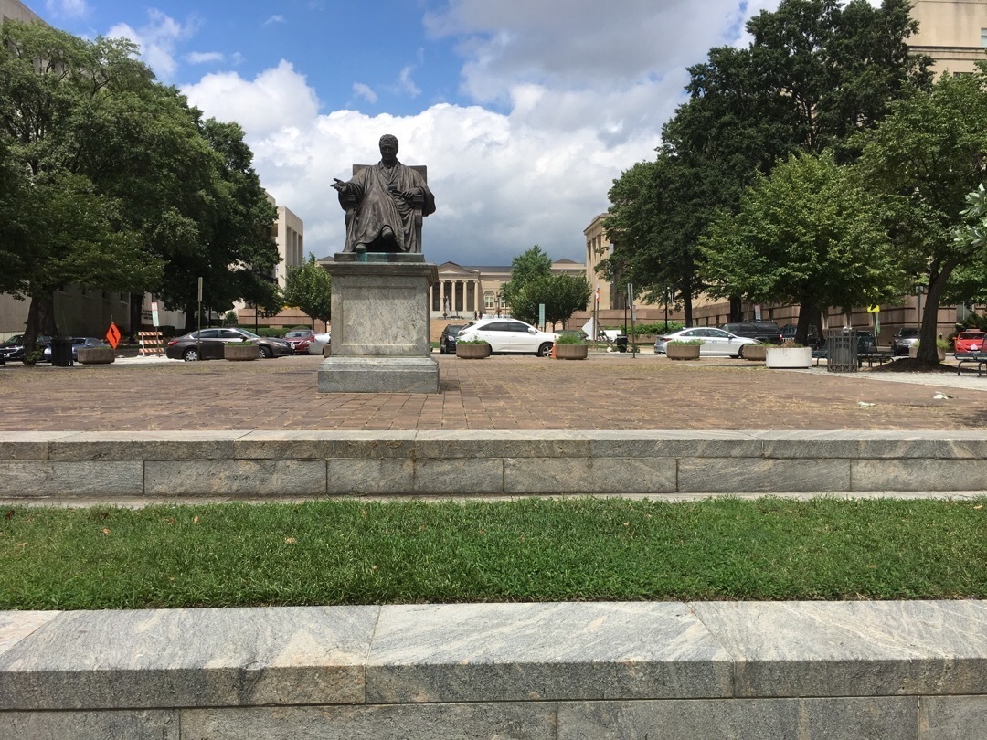 A statue of John Marshall sitting on a chair. 