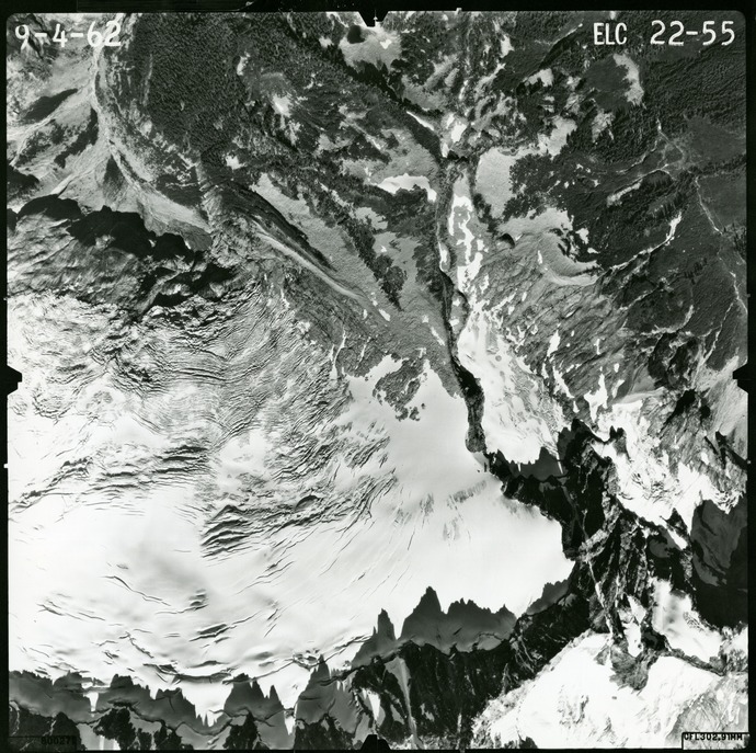 Black and white aerial photograph of glaciated mountain peaks and valleys.