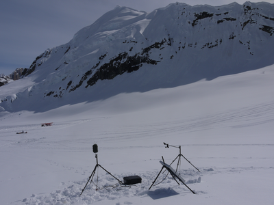 Scientific monitoring equipment composed of solar panels and microphones on tripods in areas of wilderness