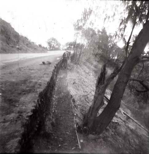 Man working on rock retaining wall alongside road at the tunnel.