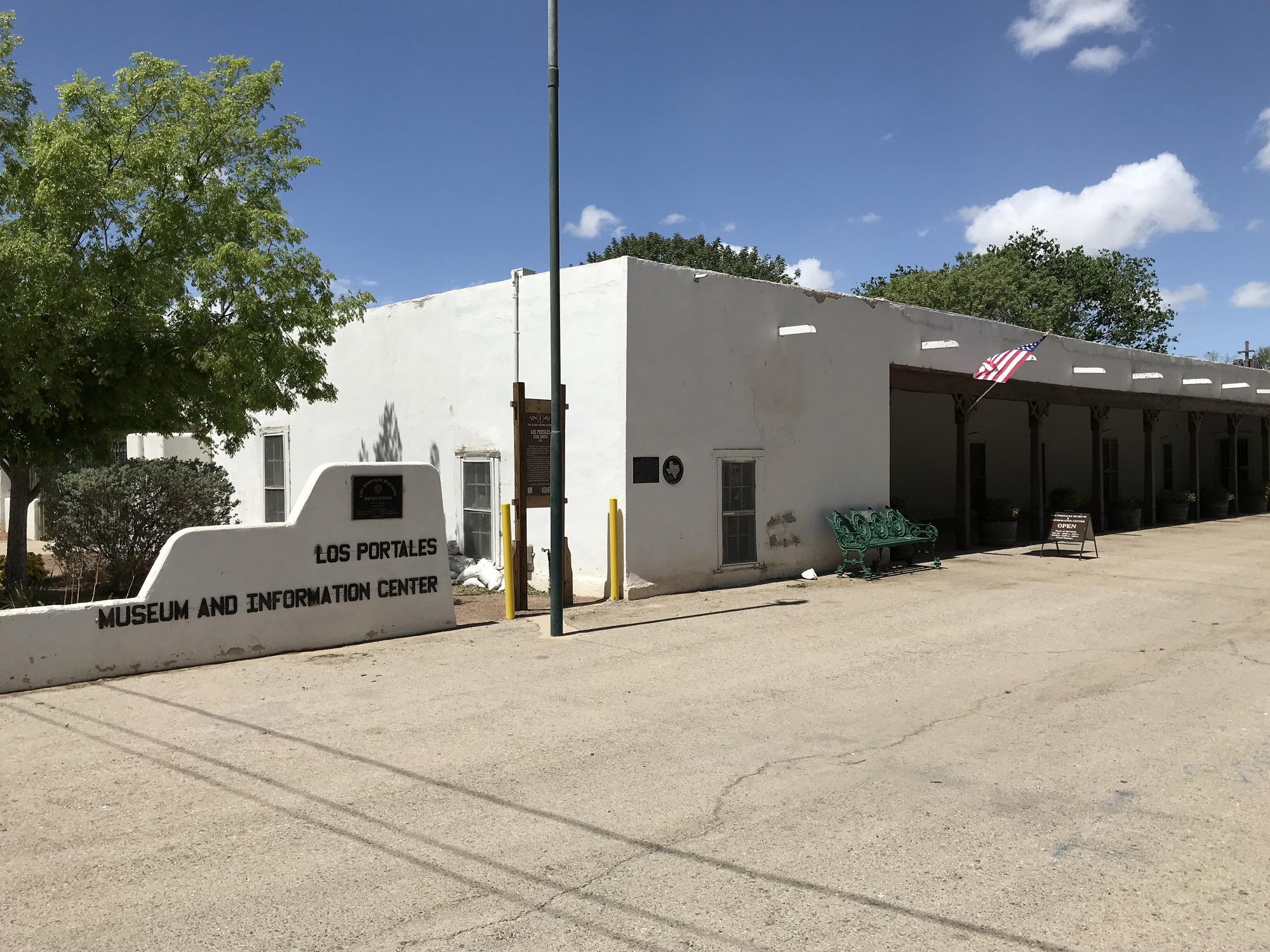 A white building with a flag in front of it.