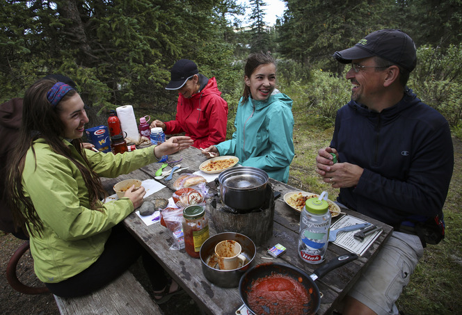 a family at a picnic table in a forest