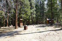 In the distance rows of wooden benches , flanked on the left and right by small wooden buildings. 